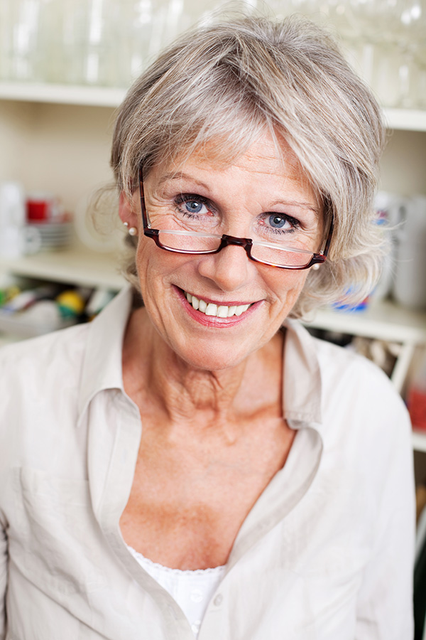 Eine Frau mit Brille im mittleren Alter schaut direkt in die Kamera.